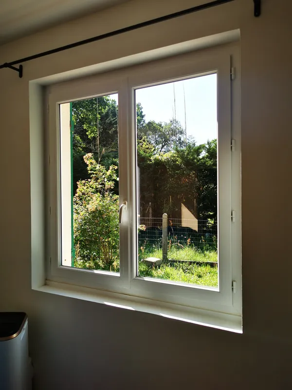 Fenêtre nettoyée avec vitres transparentes sur jardin verdoyant — Mios 2026
