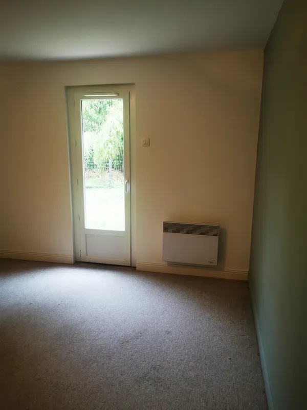 Chambre avec moquette beige encrassée, porte-fenêtre sur jardin — avant nettoyage Mios 2026