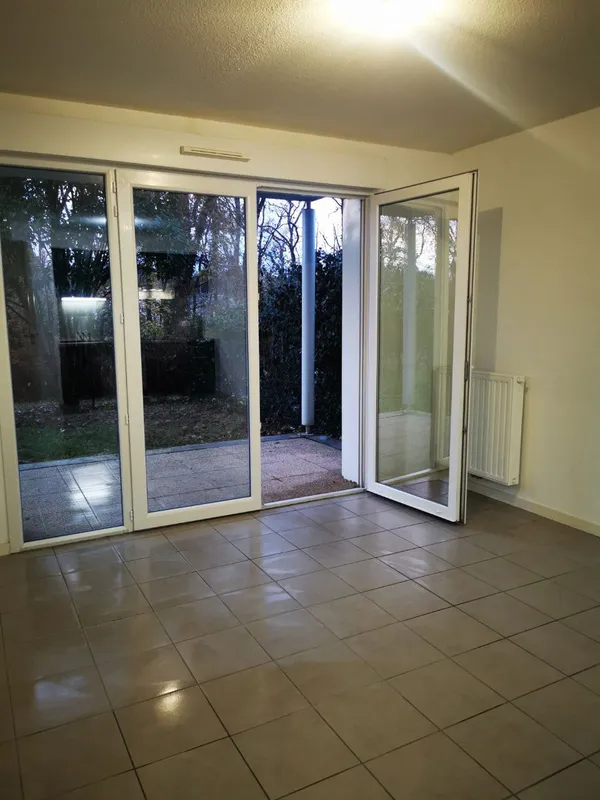Séjour nettoyé avec baies vitrées coulissantes sur terrasse, carrelage propre — fin de bail Canéjan, décembre 2025