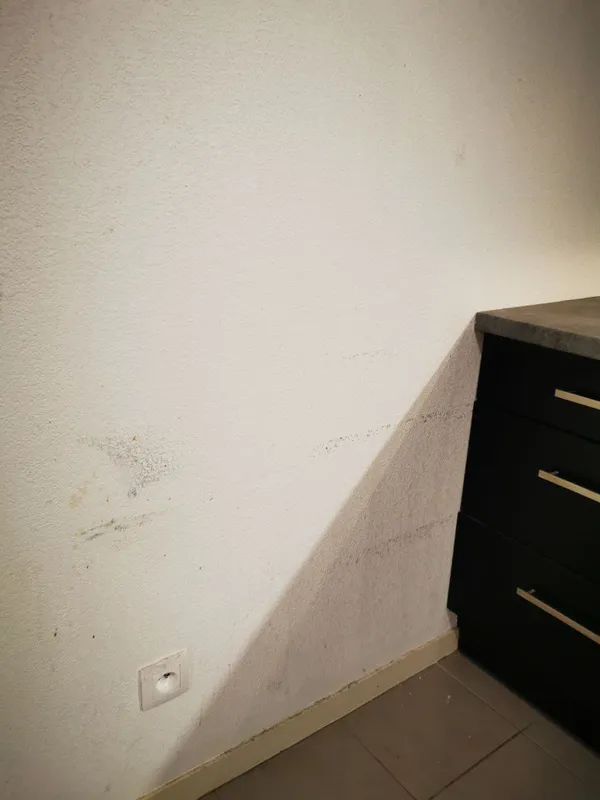 Mur de cuisine avec traces noires et moisissures près des meubles bas — Canéjan 2025