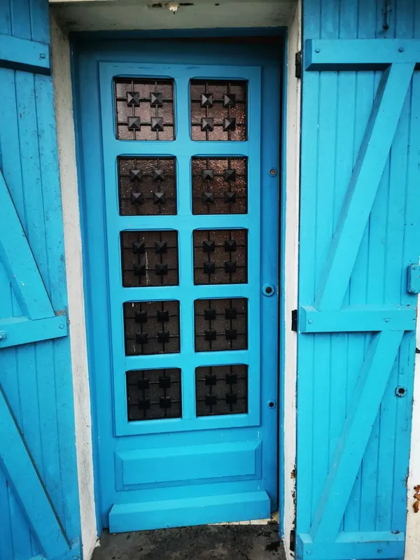 Porte d'entrée bleue à vitraux géométriques nettoyée, façade — chantier Diogène Léognan 2025