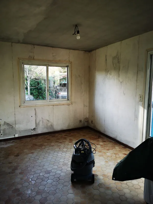 Pièce à vivre avec murs abîmés et taches d'humidité avant intervention — Léognan 2025